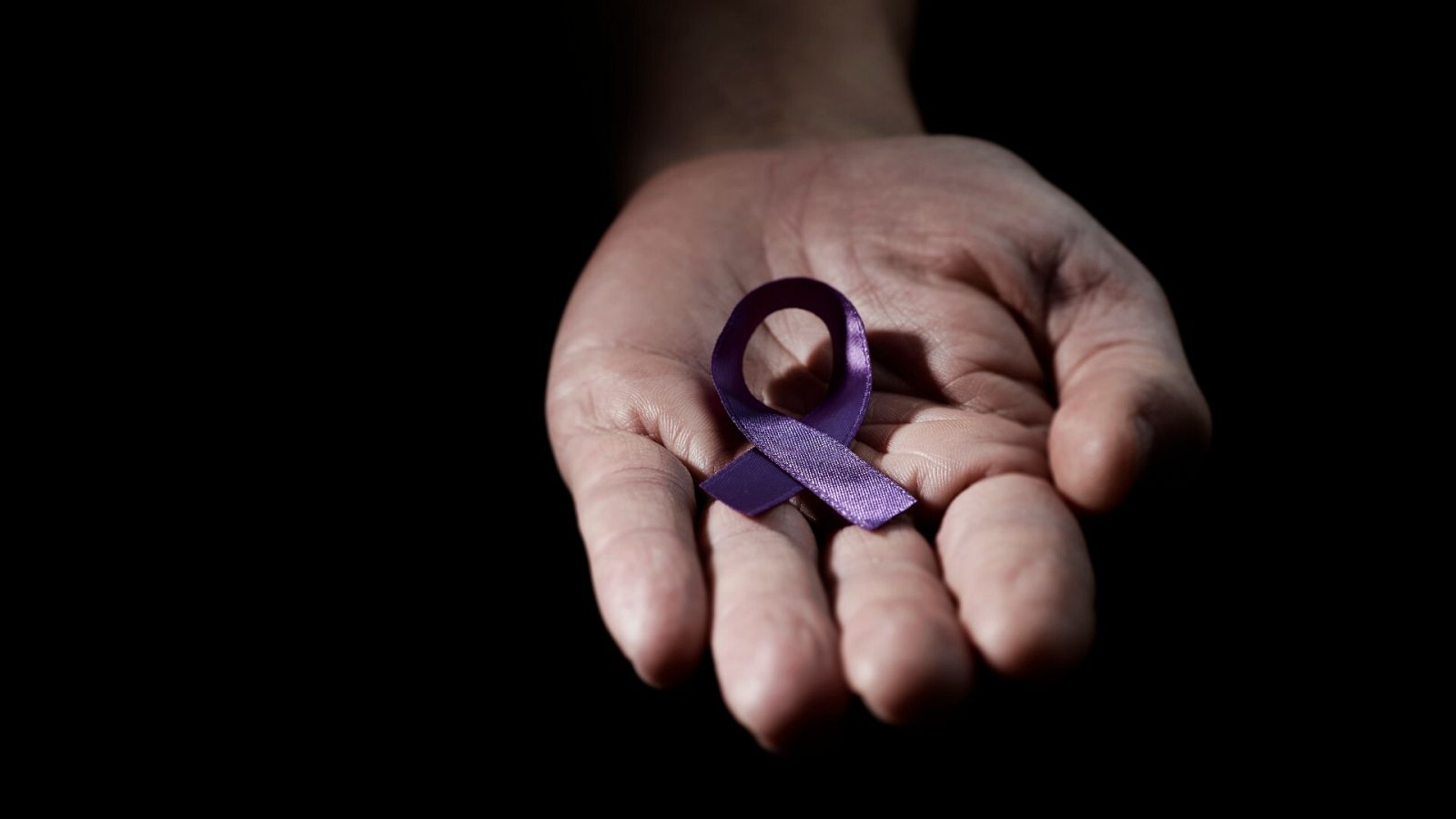 Violencia machista: Una mujer sostiene un lazo morado, símbolo contra la violencia machista