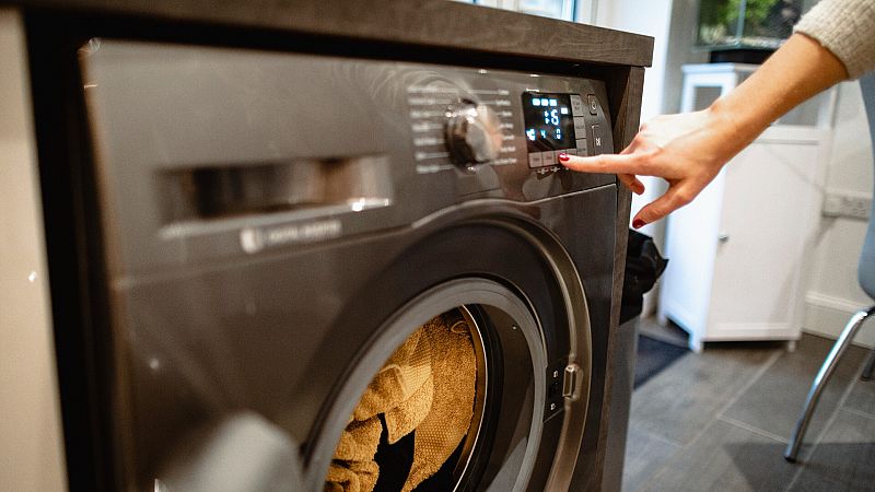 Una persona programa la lavadora