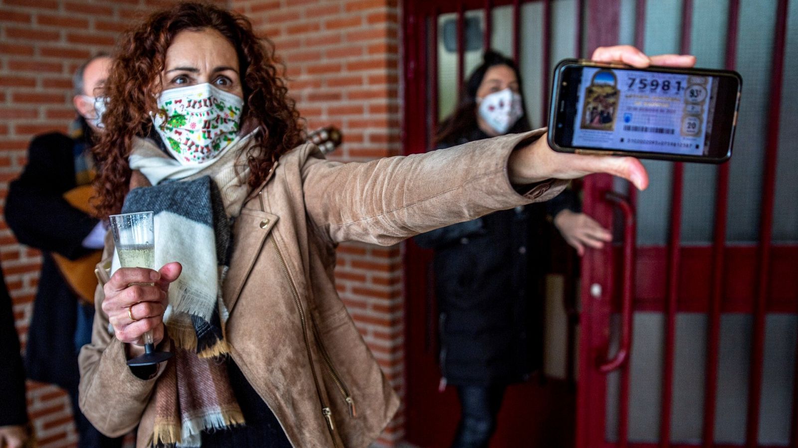 Una afortunada enseña en su móvil la foto de un décimo premiado