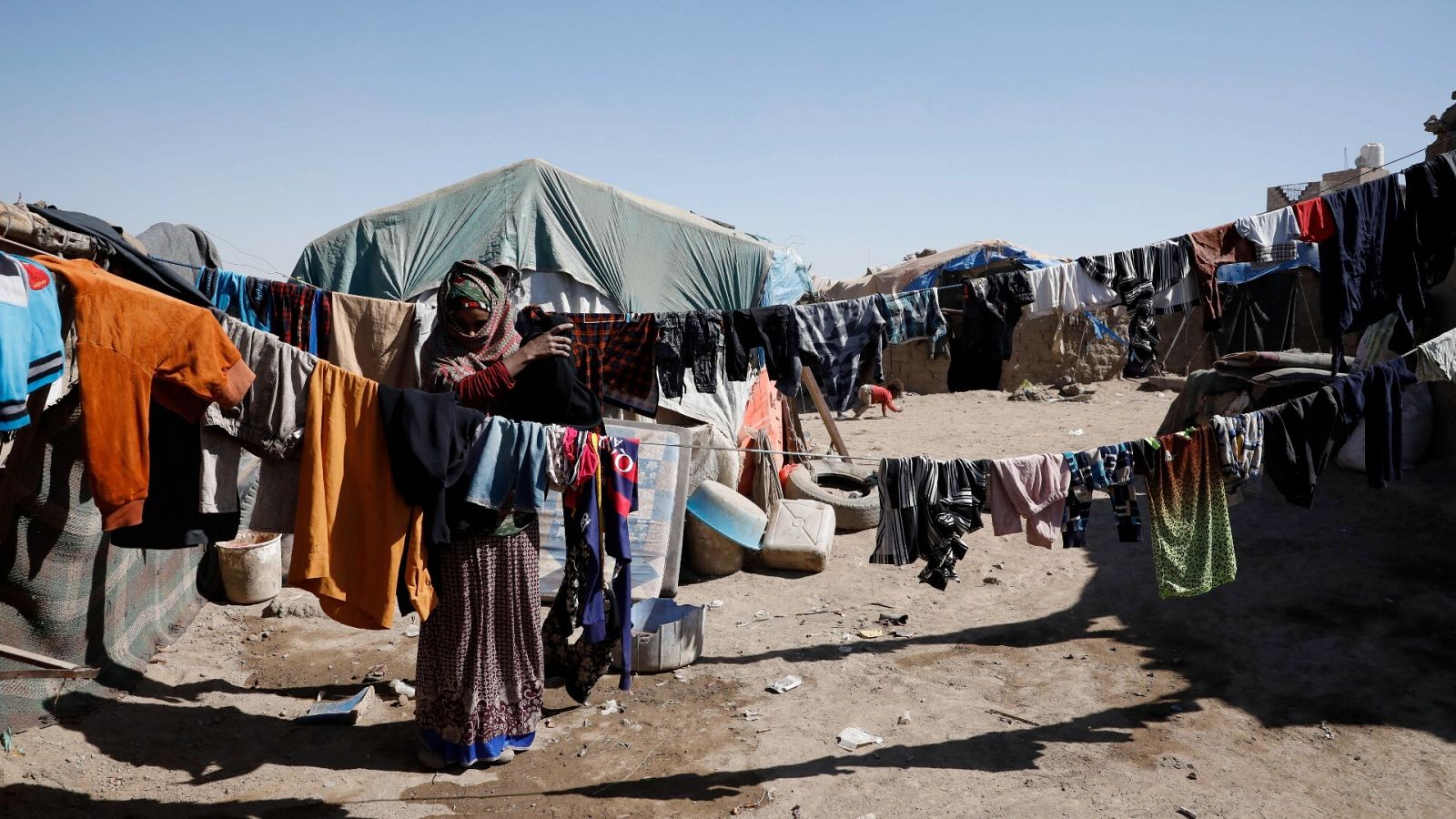 Una mujer yemení cuelga ropa en un campamento para personas desplazadas internamente en Saná, Yemen