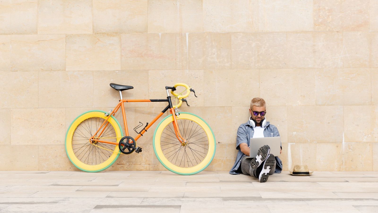 Un hombre trabaja con su portatil junto a una bicicleta en la calle, en una imagen de archivo