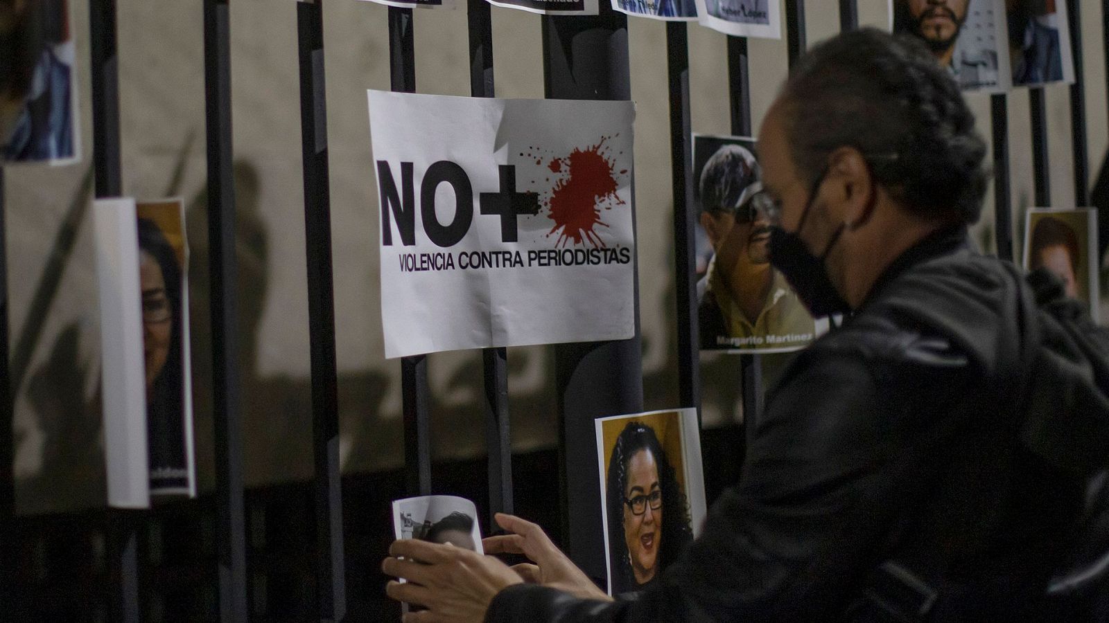 Una persona cuelga una fotografía demandando justicia por los asesinatos de periodistas frente a la Secretaría de Gobernación en Ciudad de México (México)