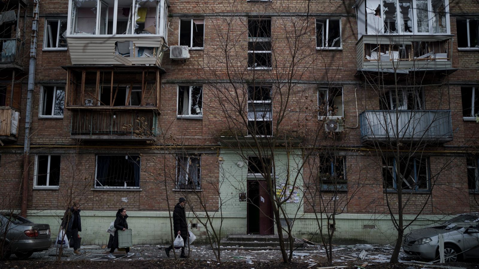 Vecinos retiran sus pertenencias de un edificio dañado en Kiev, Ucrania