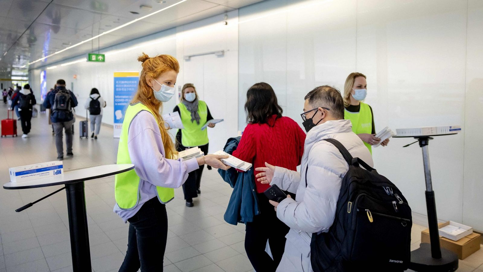 Un empleado del Servicio Municipal de Salud de los Países Bajos reparte kits gratuitos de autodiagnóstico a los viajeros procedentes de China