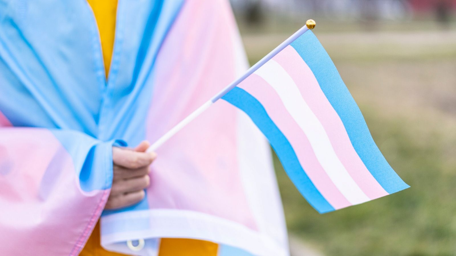 Una persona sostiene una bandera del orgullo trans en una imagen de archivo