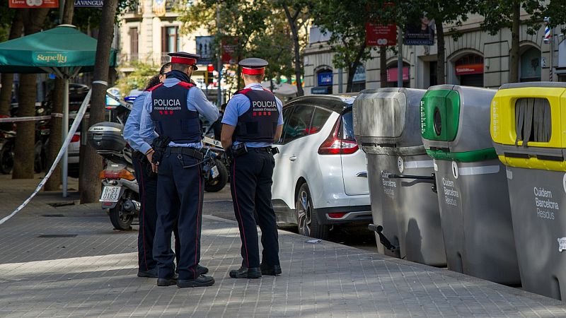 Imagen de archivo de unos Mossos d'Esquadra junto a unos contenedores en el centro de una ciudad