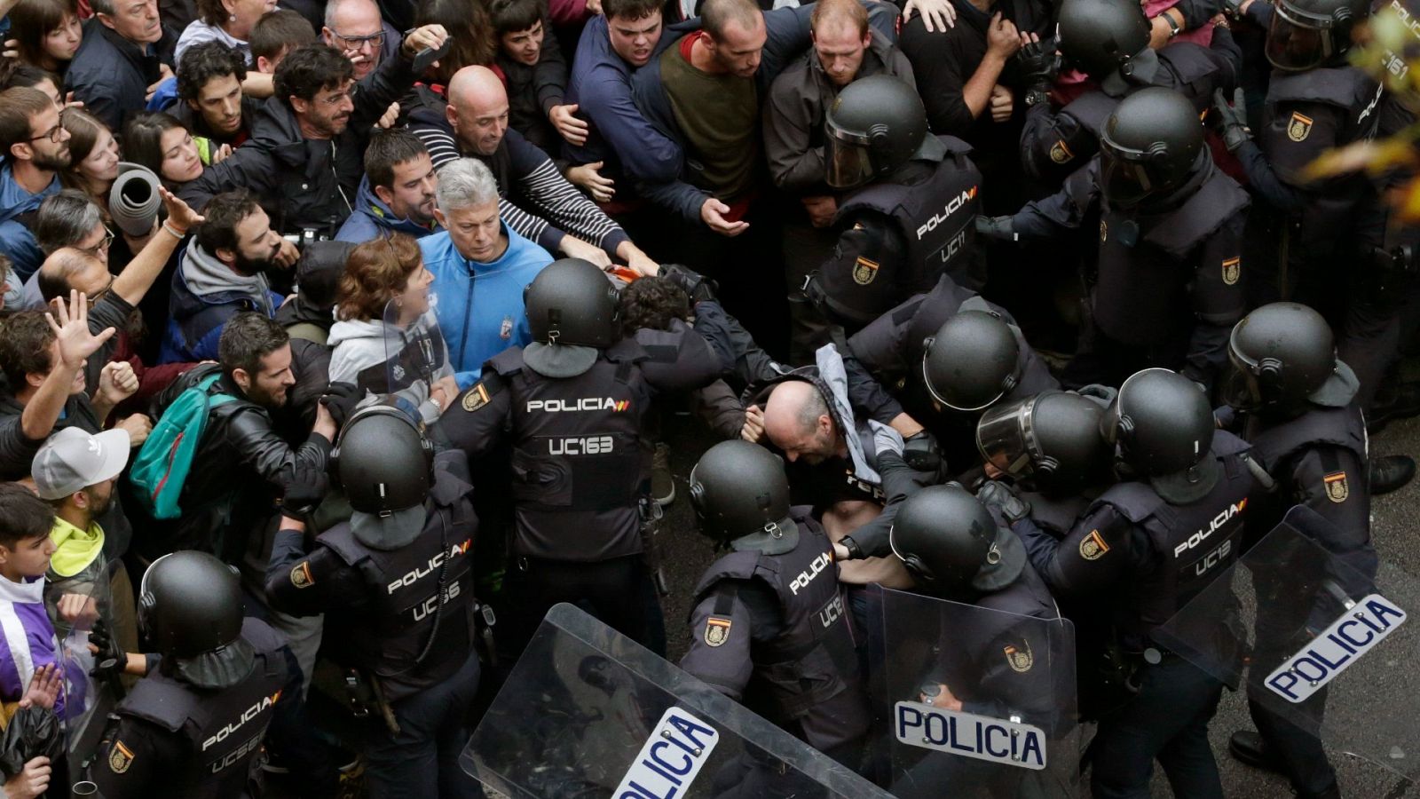 Agentes antidisturbios de la Policía Nacional forman un cordón de seguridad frente al colegio Ramón Llull de Barcelona durante el referéndum ilegal del 1-O de 2017