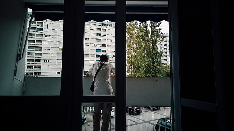 Una persona asomada a un balcón