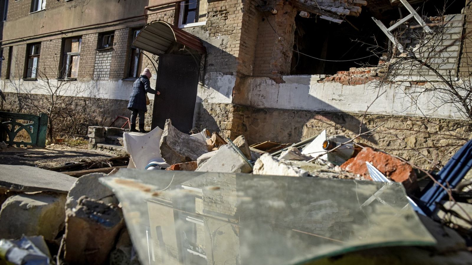 Una mujer entra en su edificio derruido en la ciudad de Donetsk