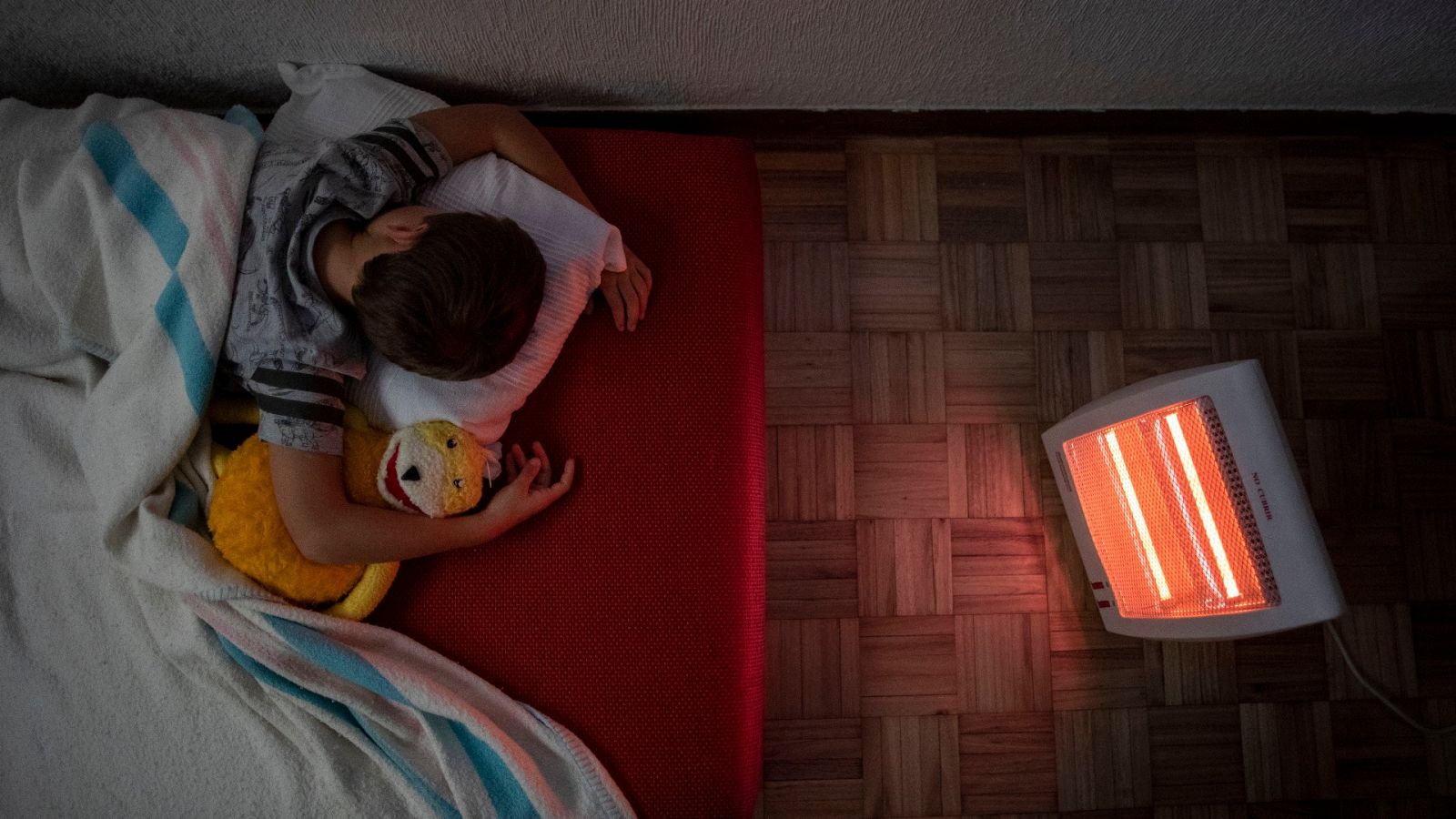 La pobreza energética en España: un niño duerme junto a un calefactor