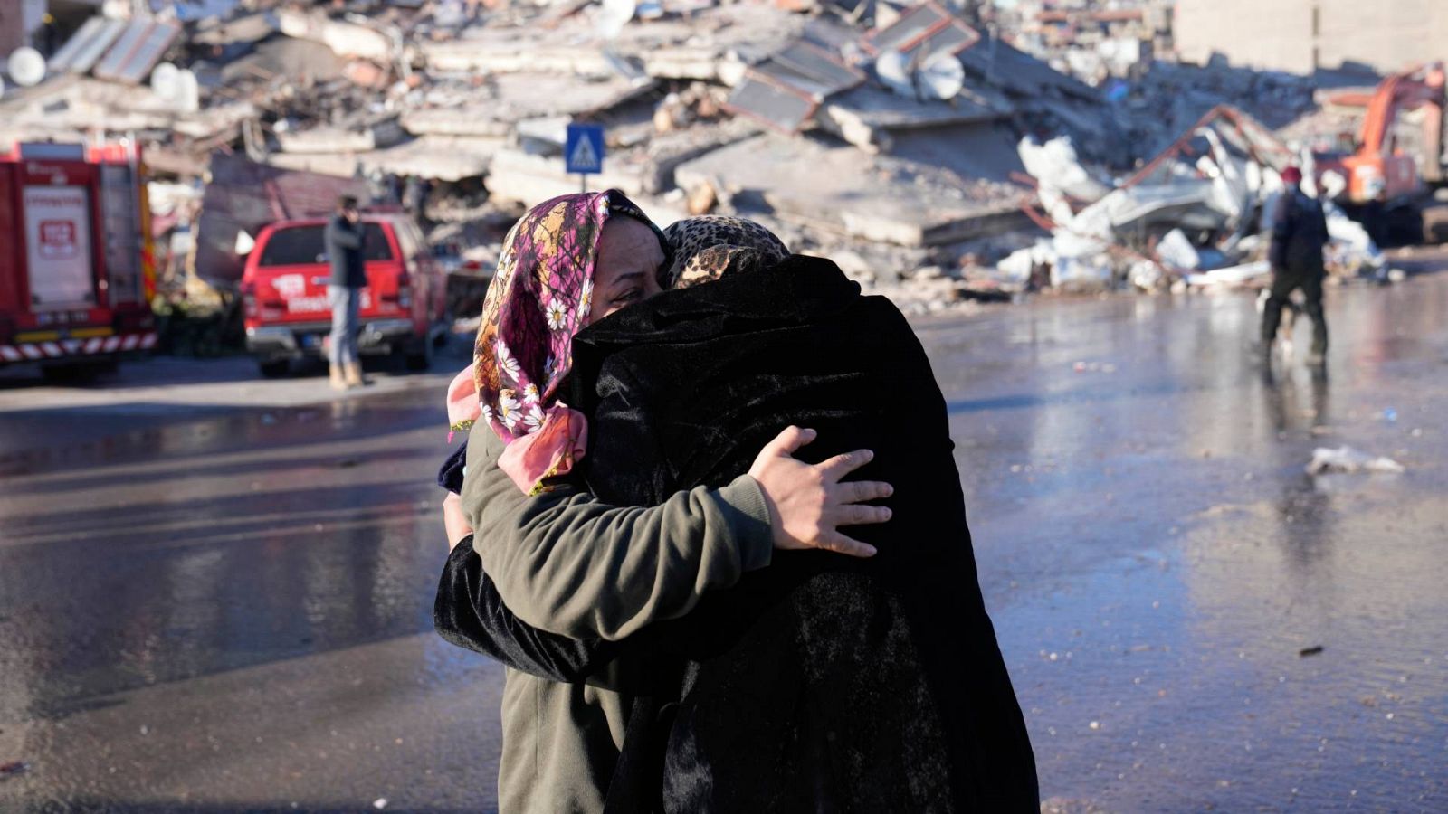 Dos mujeres se abrazan frente a un edificio derruido en Kahramanmarash, Turquía