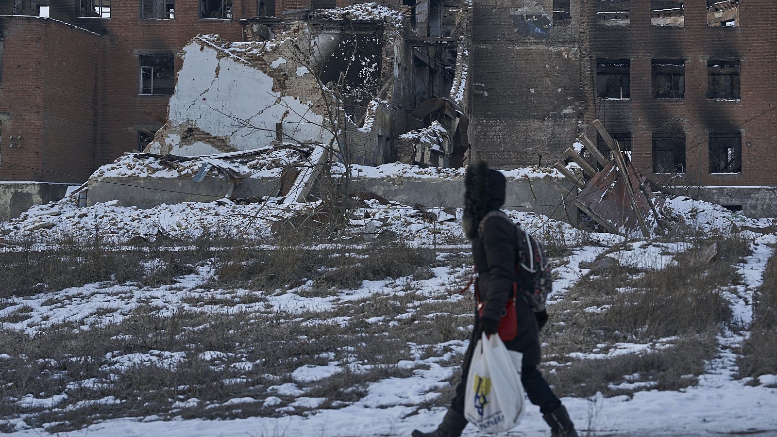 Una mujer pasa delante de un edificio destrozado por la guerra en Donetsk