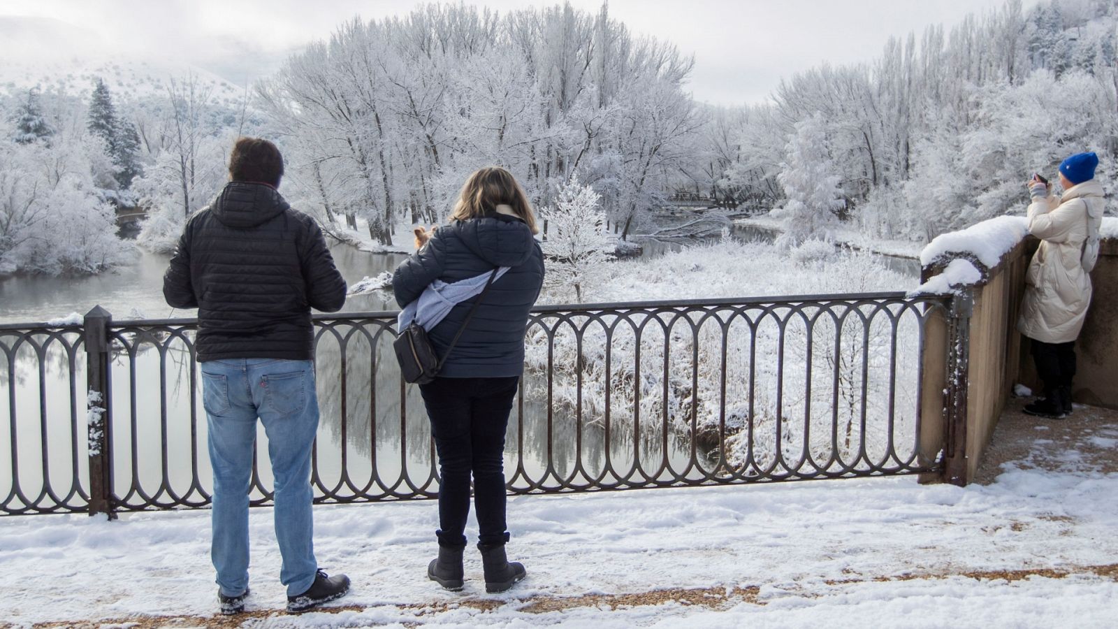 Dos turistas hacen fotos junto al río Duero en Soria.