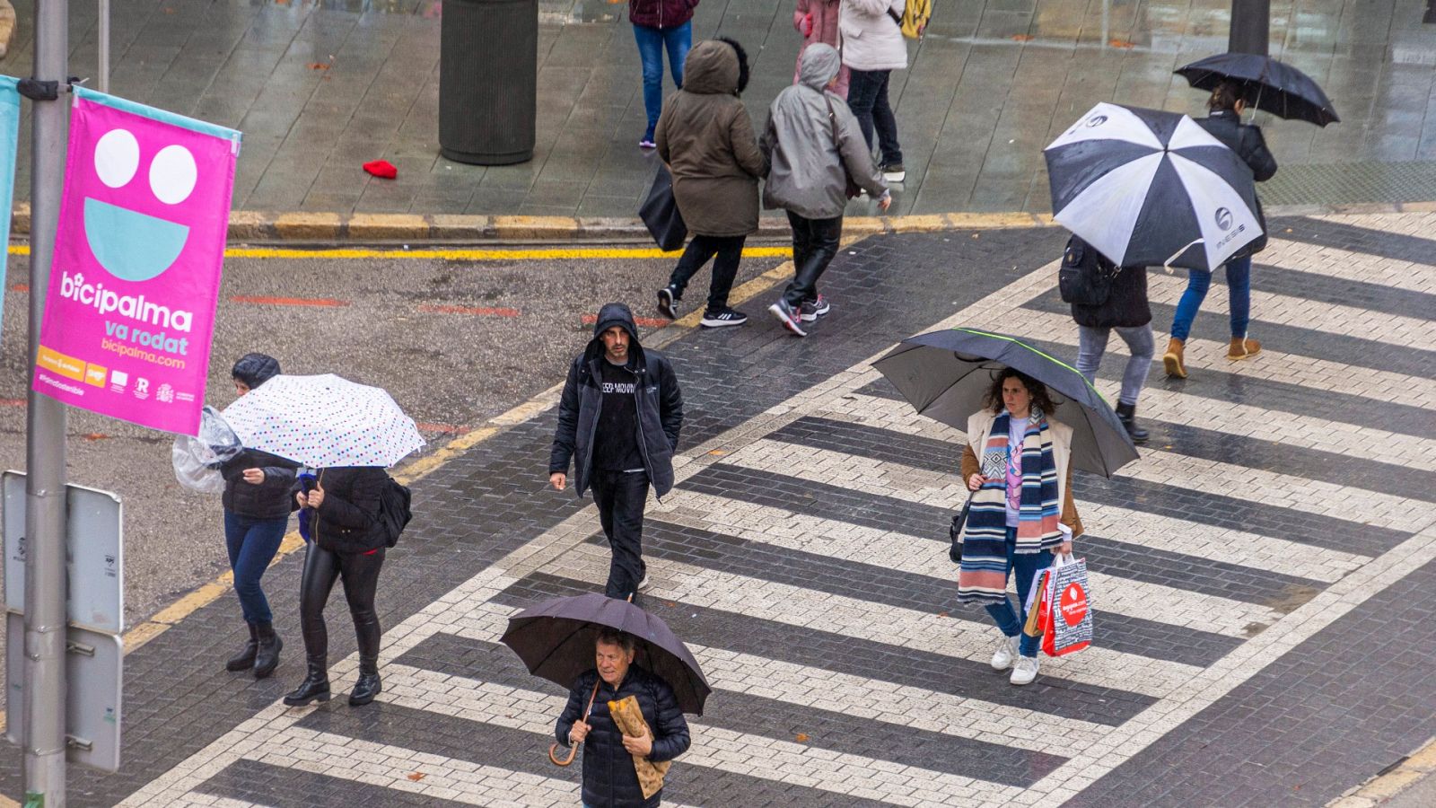 Peatones se protegen con paraguas de la lluvia en Palma de Mallorca