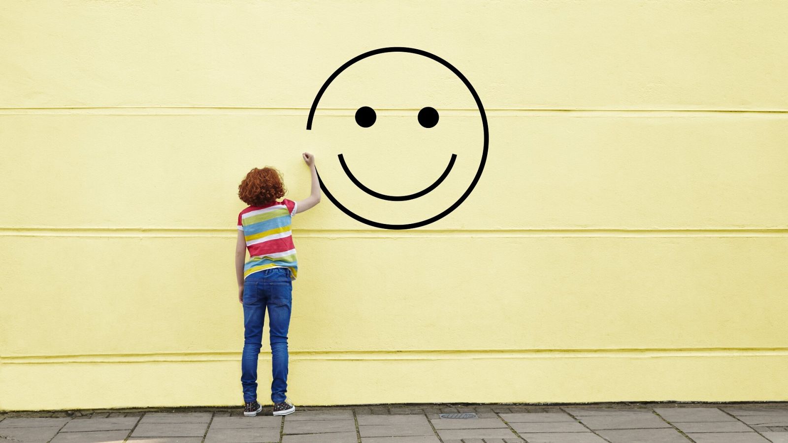 ¿Qué es la felicidad?: Una cara sonriente pintada en un muro amarillo