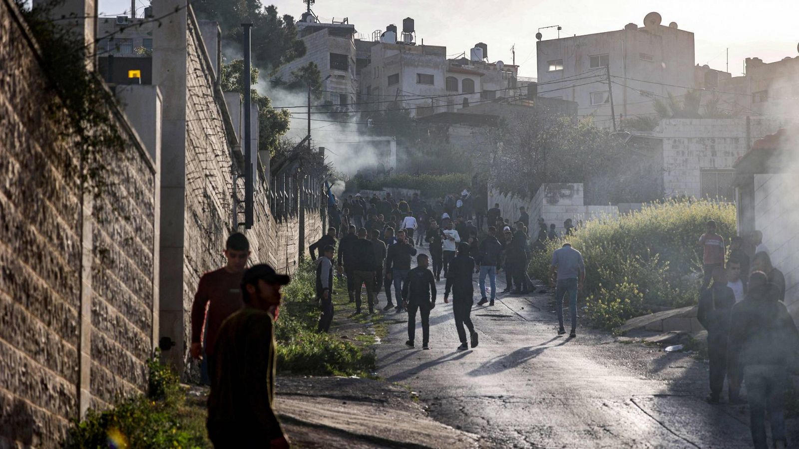 Un grupo de palestinos se reúnen a lo largo de una carretera durante una redada del ejército israelí en el campamento de refugiados palestinos de Yenín en la Cisjordania