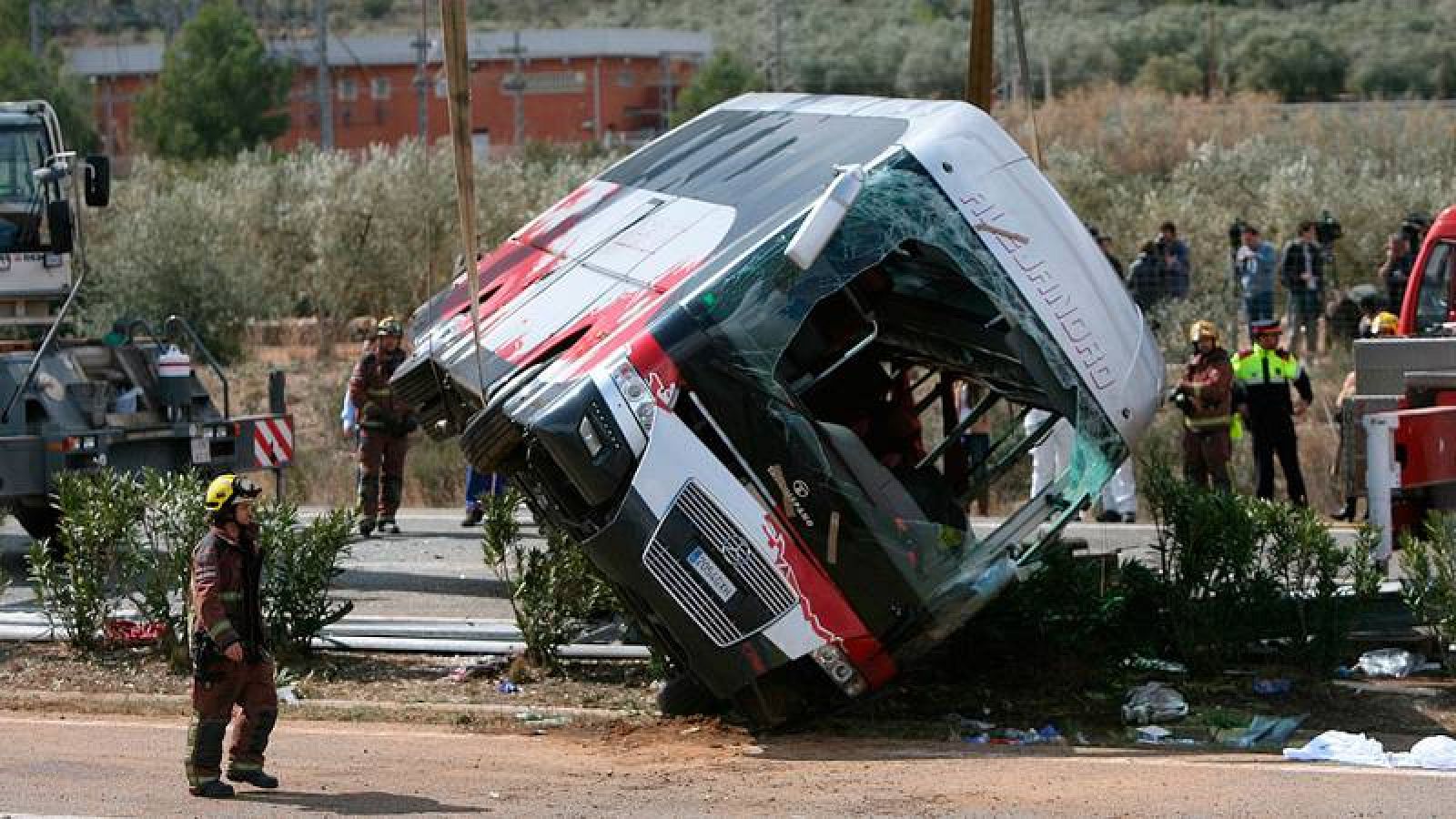 Efectius d'emergències redrecen l'autobús que havia bolcat al voral de la carretera