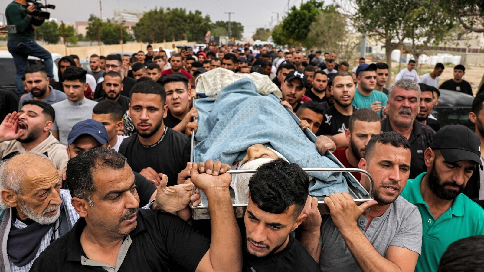 Un grupo de personas marcha con el cuerpo del adolescente palestino de 15 años fallecido en Jericó