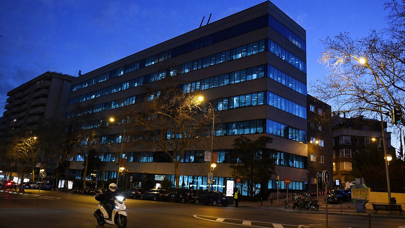 Fachada iluminada al anochecer de la sede de Ferrovial en Madrid