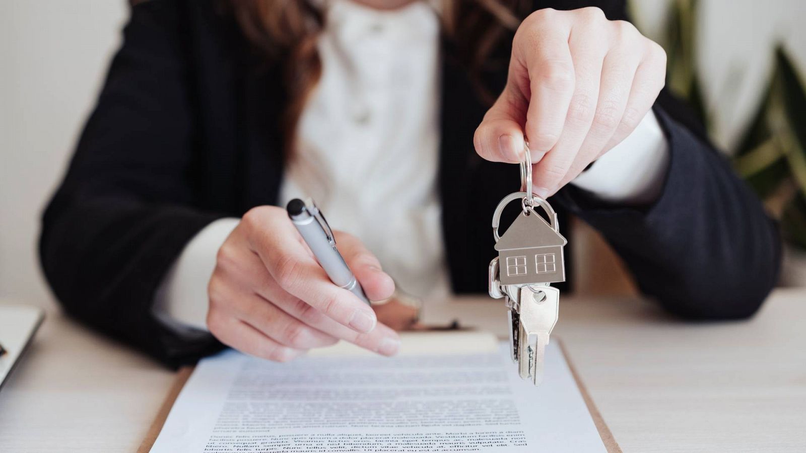 Una mujer firmando la compra de su vivienda, en una imagen de archivo