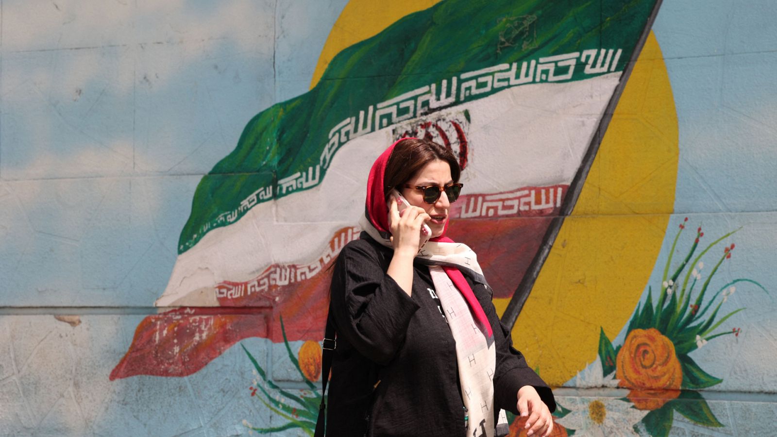 Una mujer con velo habla por teléfono en Teherán, Irán