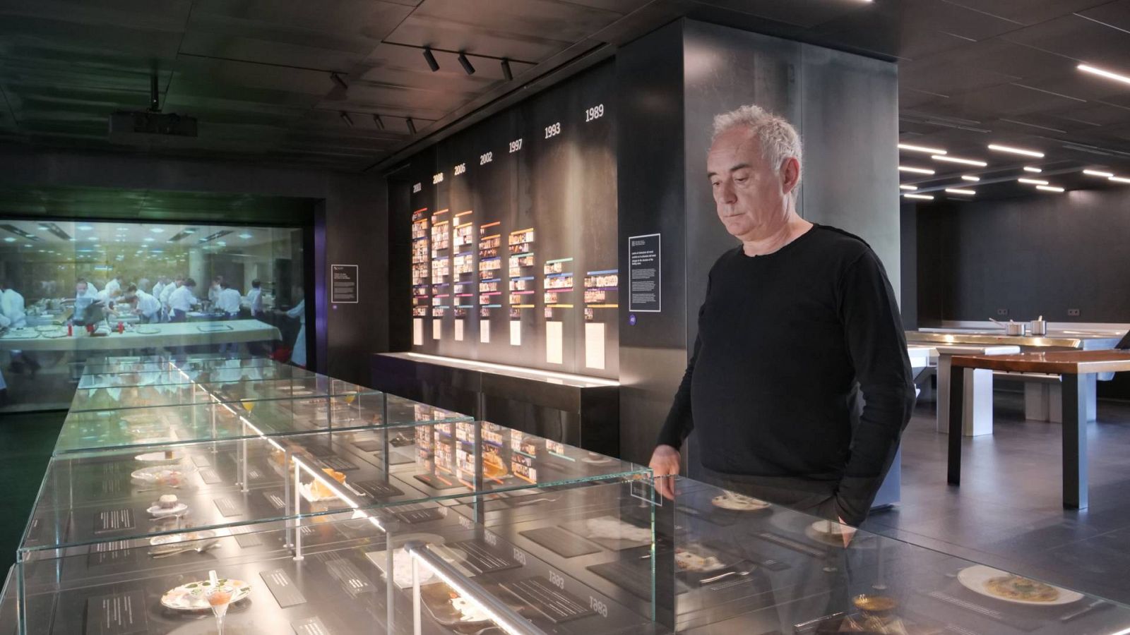 Ferran Adrià posando ante la vitrina en la que se reproducen algunos de sus platos más icónicos.