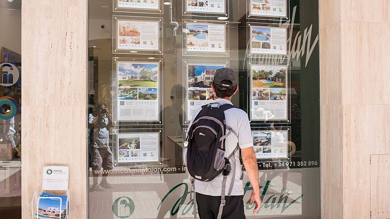 En la imagen, un hombre observa carteles de viviendas en venta y alquiler en Menorca