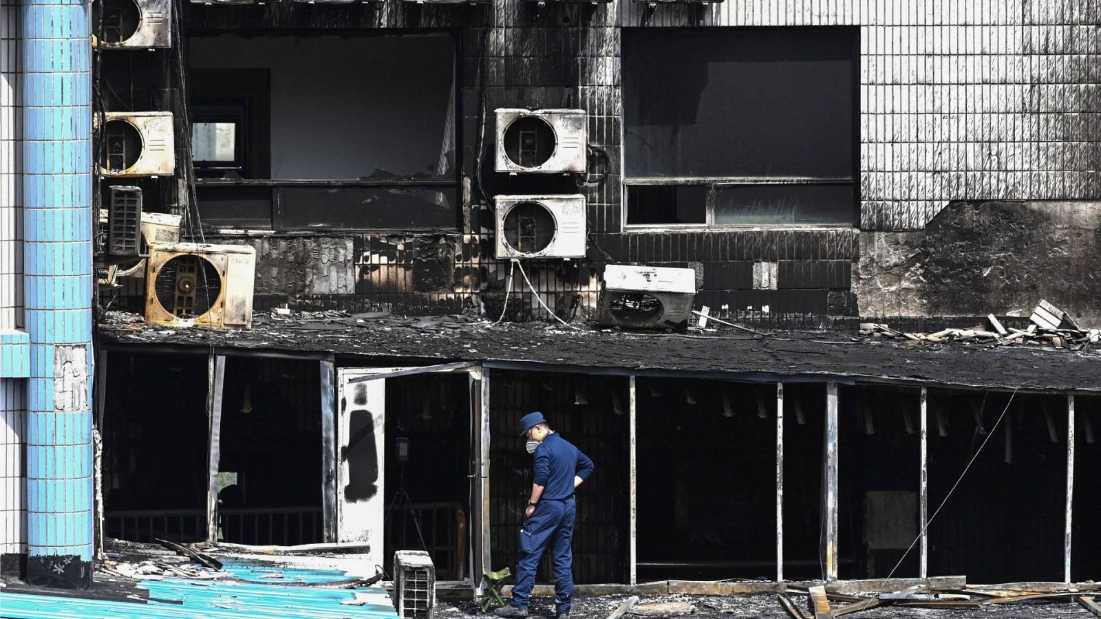 Un investigador inspecciona los daños en el hospital Changfeng de Pekín tras el incendio que ha matado a más de una veintena de personas (19 de abril de 2023). Foto: GREG BAKER / AFP