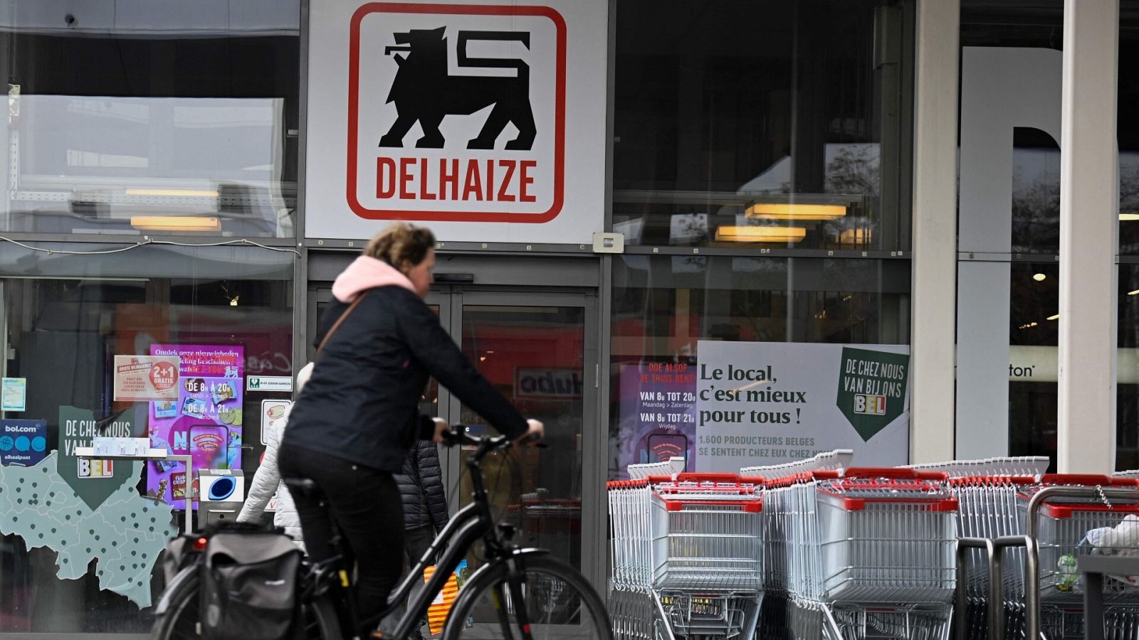 Una ciclista delante de un supermercado belga