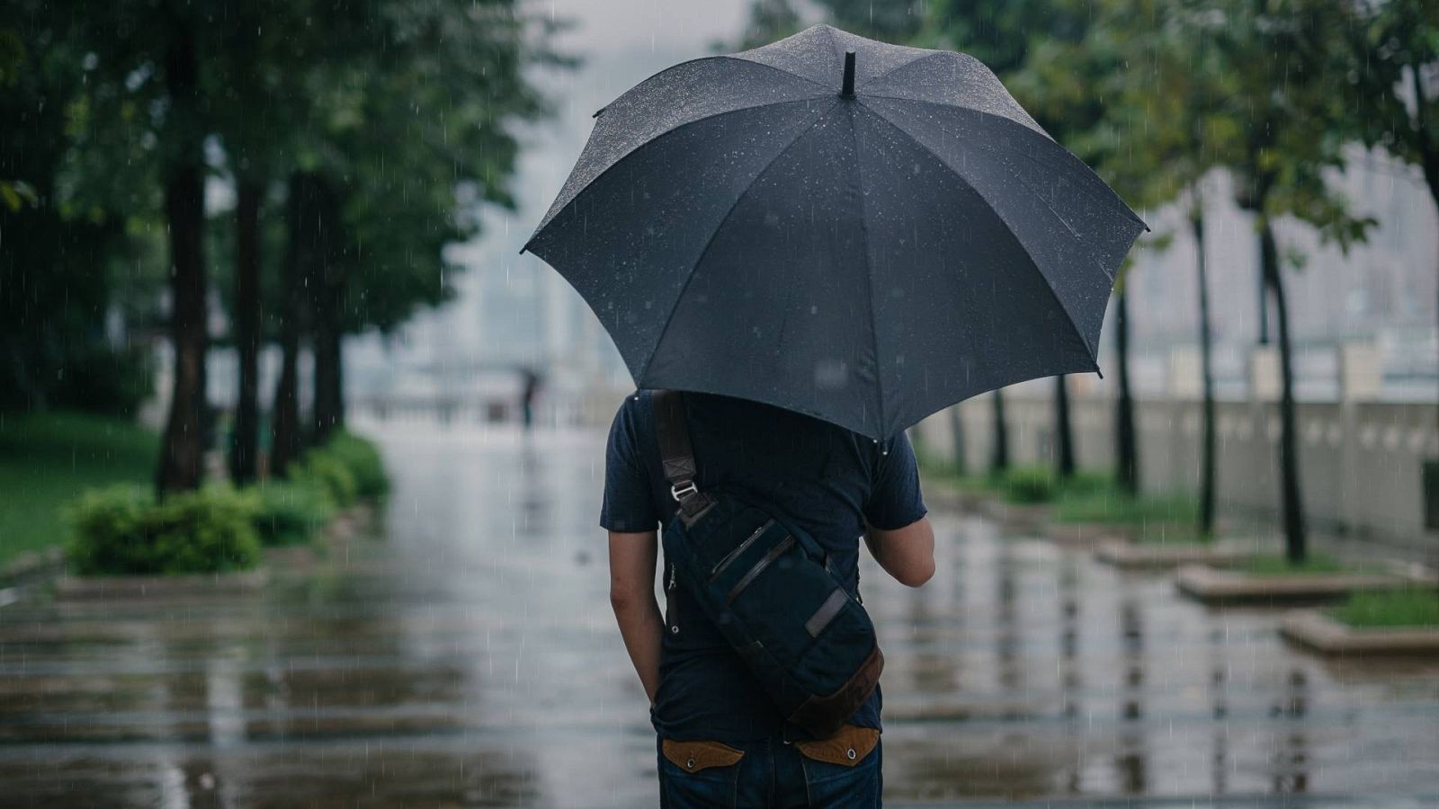 Un hombre sostiene un paraguas refugiándose de la lluvia, en una imagen de archivo