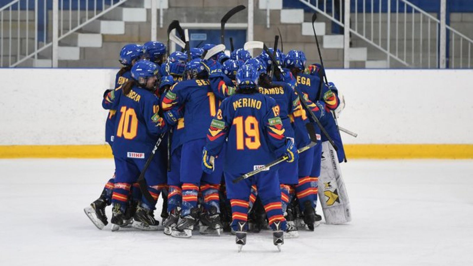 La selección española femenina de hockey sobre hielo celebra en el centro de la pista