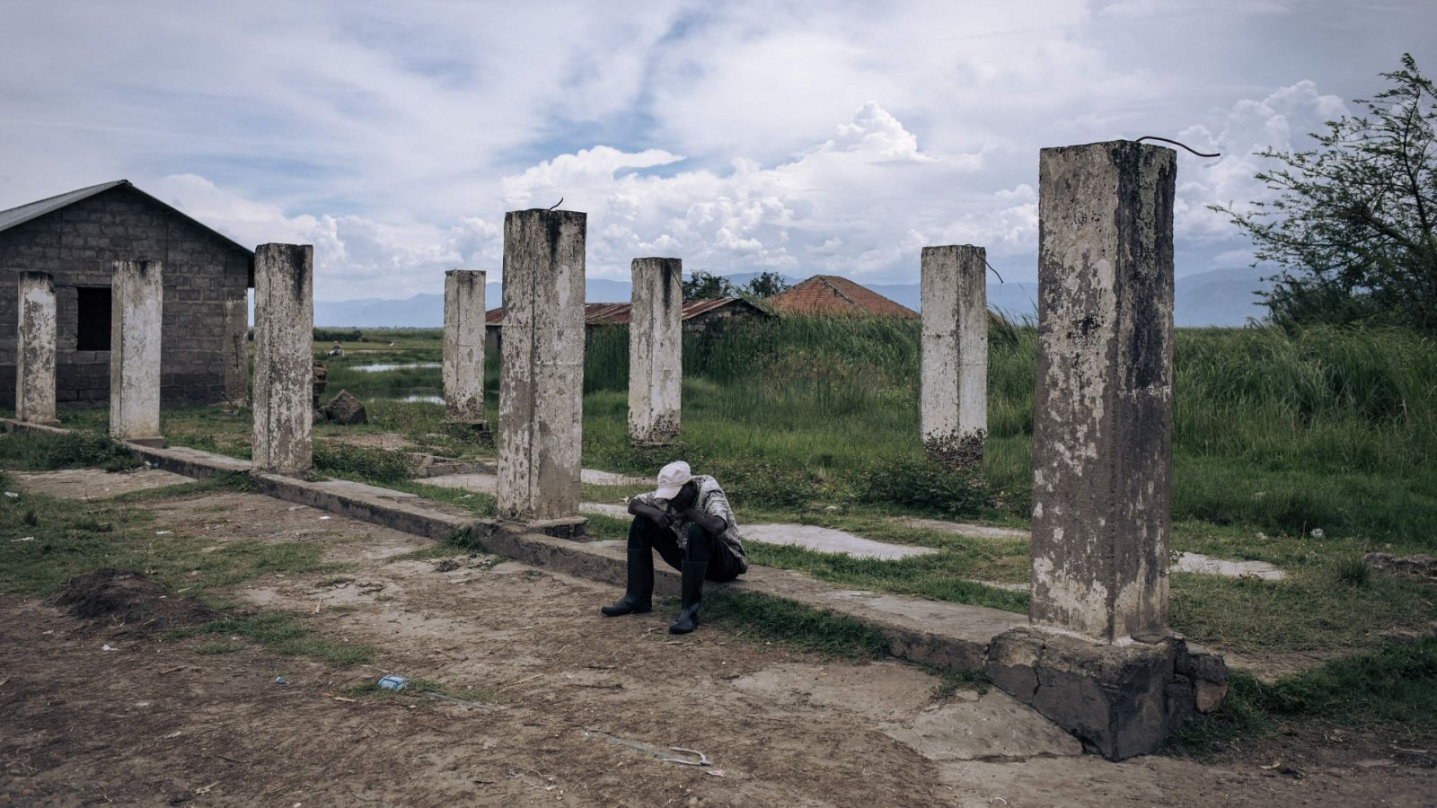 Un hombre sentado sobre las ruinas de un almacén en una localidad del este de la República Democrática del Congo (Archivo)