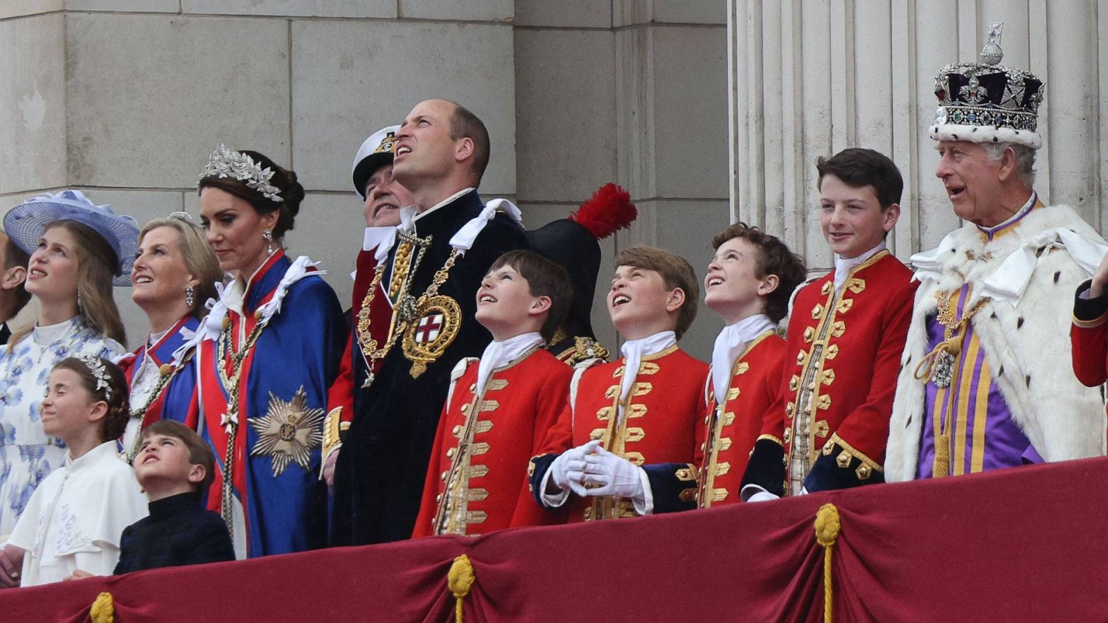 La familia real en el balcón del palacio de Buckingham: a la derecha aparece el rey Carlos III y en el centro, con capa negra, el heredero al trono, Guillermo de Gales; el tercer paje por la derecha es su hijo y segundo en la línea de sucesión, Jorge