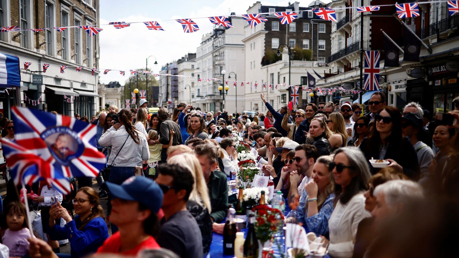 Cientos de personas participan en un gran almuerzo para celebrar la coronación del rey Carlos III en una calle en Londres