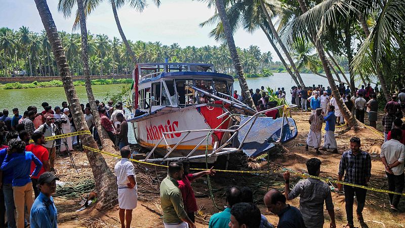 Los transeúntes se acercan al lugar del accidente de una embarcación en Tanur