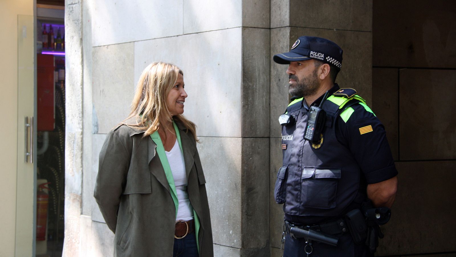 La candidata de Valents, Eva Parera, conversa amb un agent de la Guàrdia Urbana