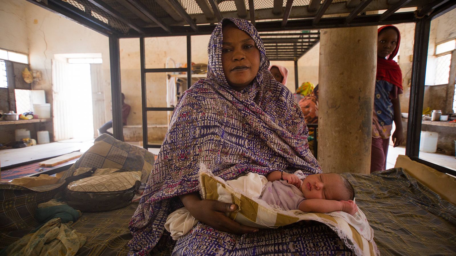 Hawa abraza a su hijo recién nacido, que dio a luz en el refugio temporal después de que su familia fuera desplazada.