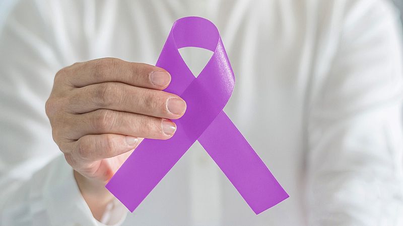 Una mujer sujeta un lazo morado, símbolo contra la violencia machista