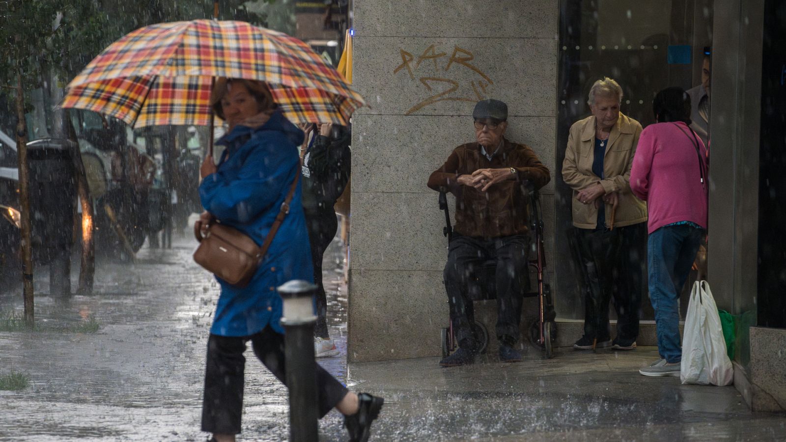 Una mujer se resguarda d ela lluvia con un paraguas.