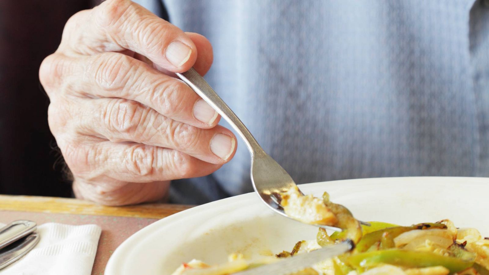 Sancionan a una residencia de mayores por servir comida caducada: Una persona mayor comiendo