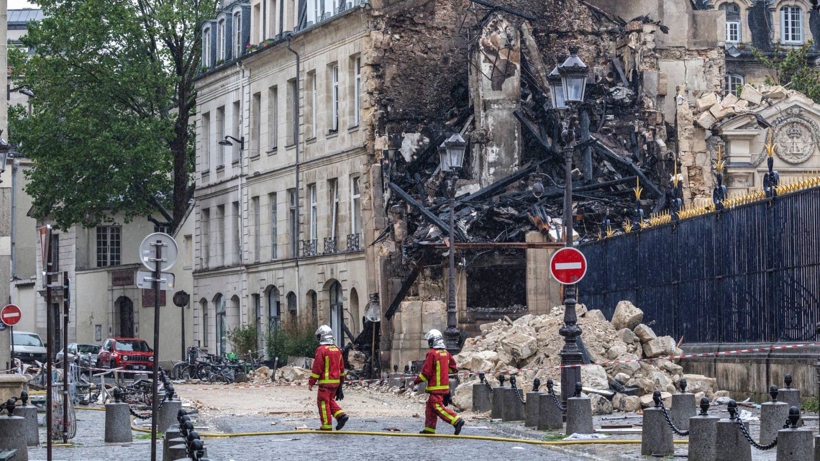 Dos trabajadores de los servicios de emergencia entre las ruinas de un edificio parisino