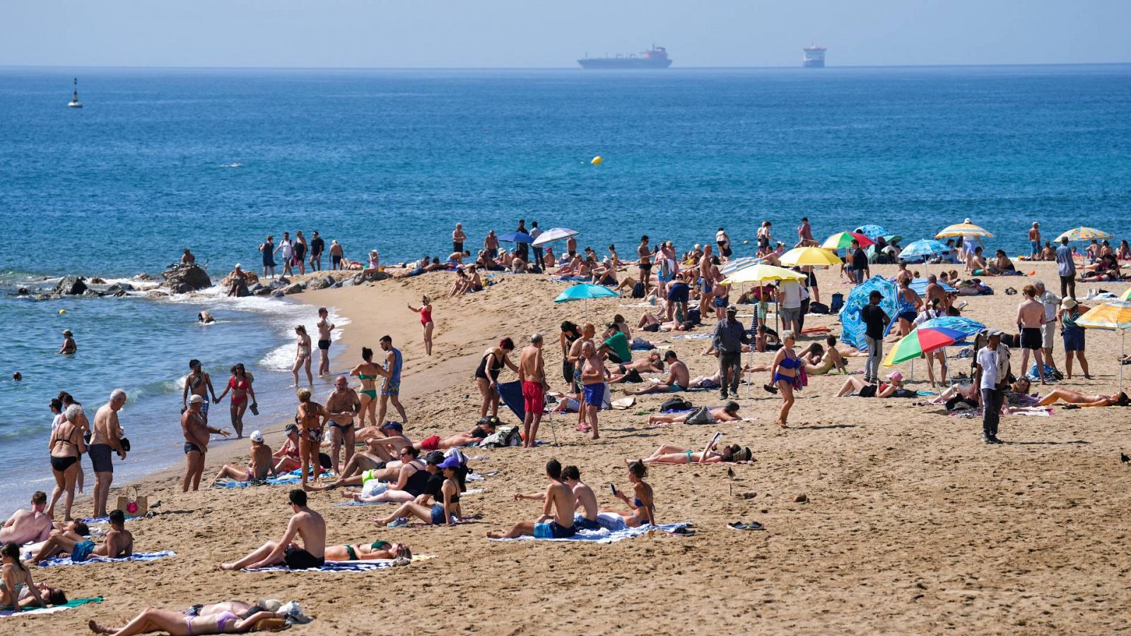 Varios bañistas disfrutan del mar este jueves en la playa de la Barceloneta de Barcelona