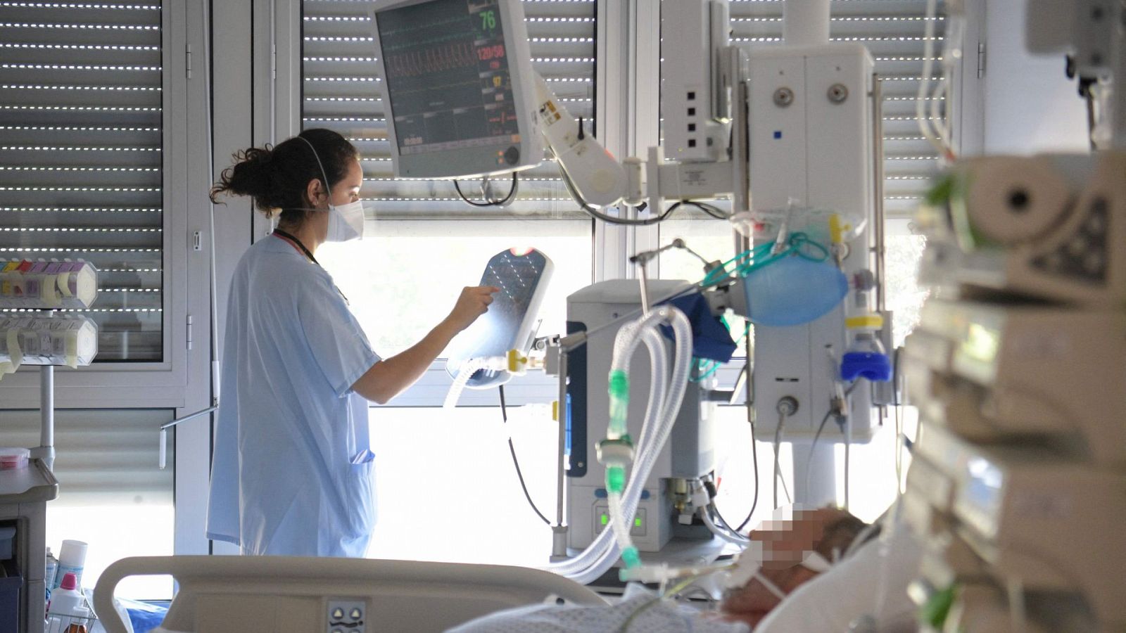 Una sanitaria atiende a las máquinas dE un paciente en el hospital