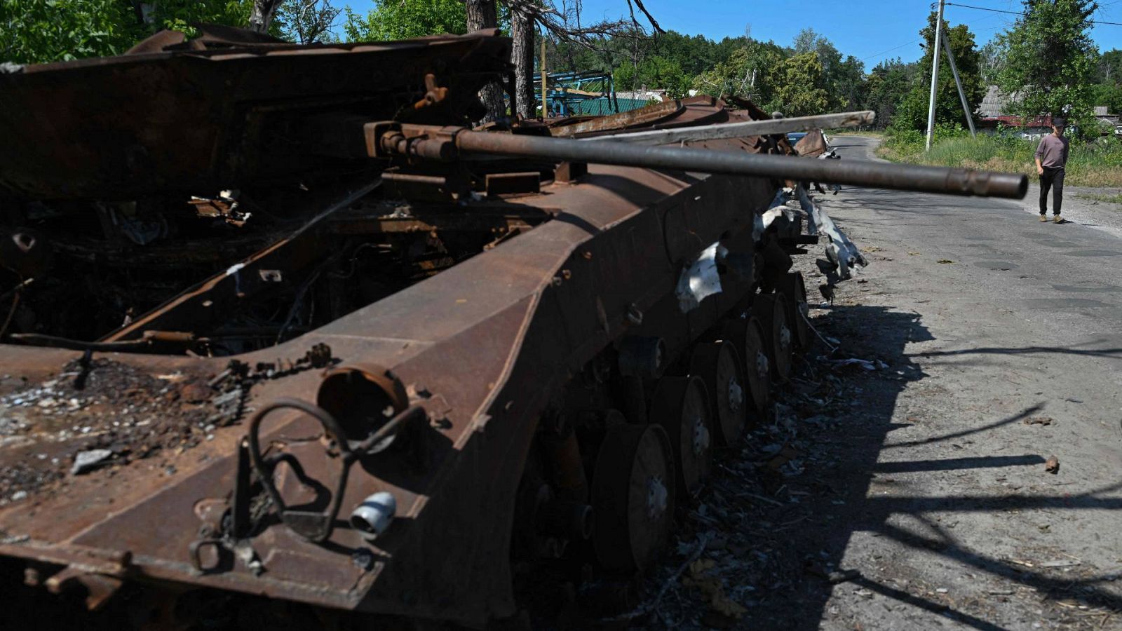 Un hombre camina junto a un tanque ruso destruido en Donetsk.