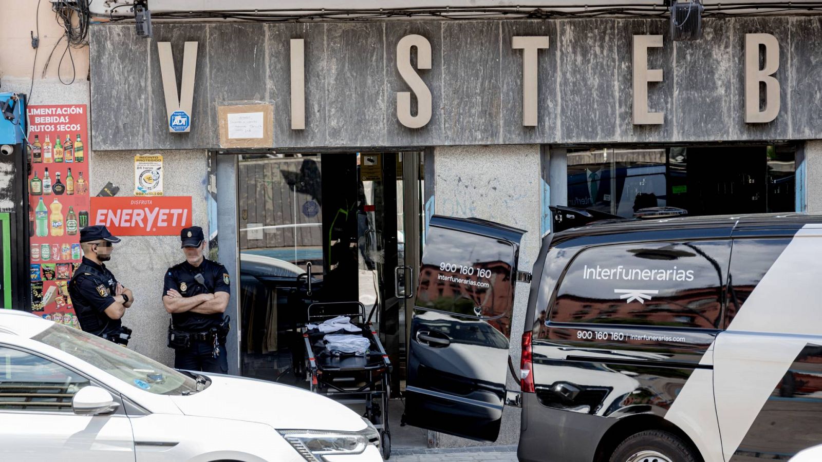 Dos agentes de Policía Nacional junto con el vehículo de Interfunerarias en el lugar donde se han producido los hechos