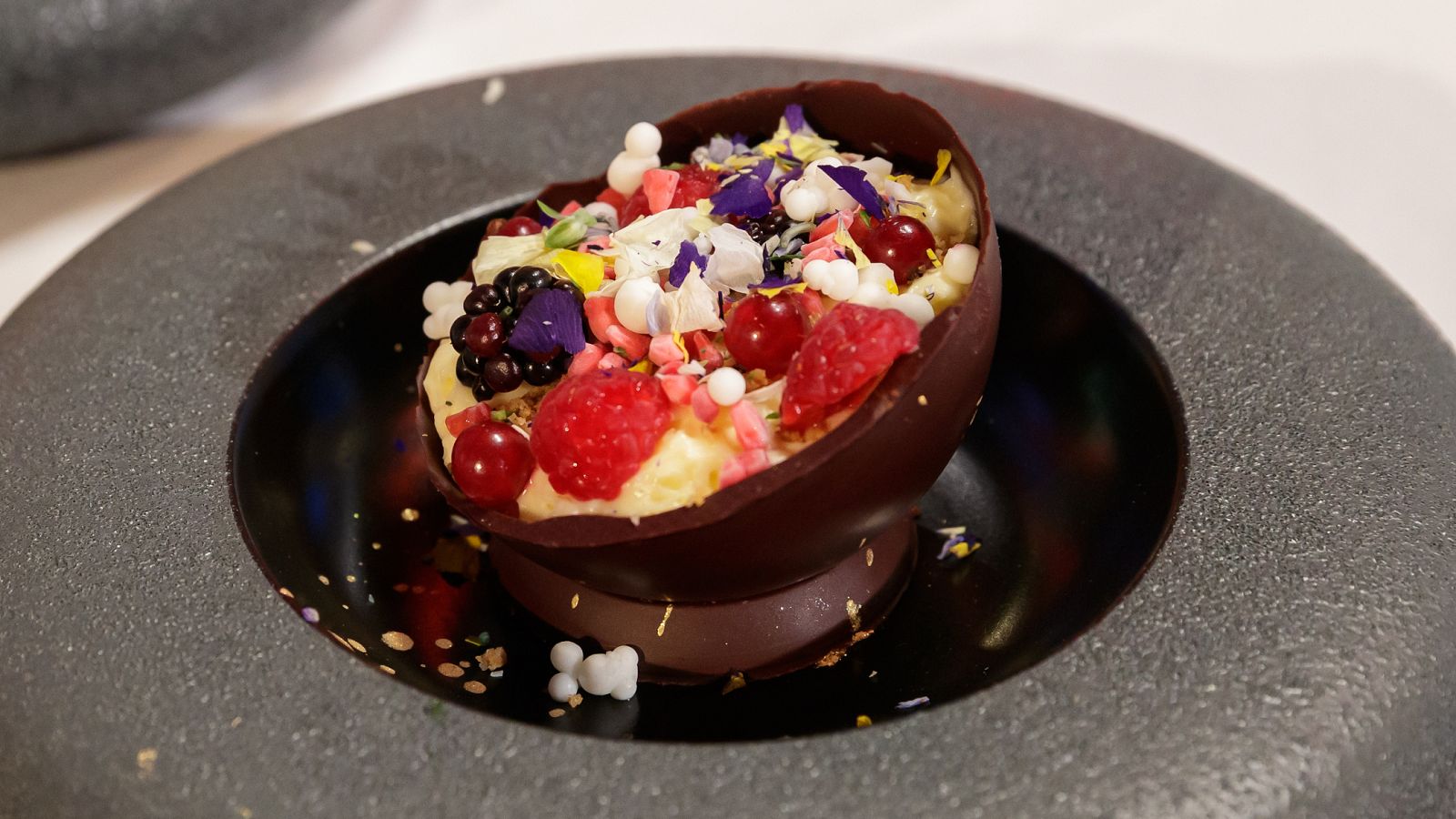 Esfera de chocolate con espuma de crema catalana y frutos rojos de Alex