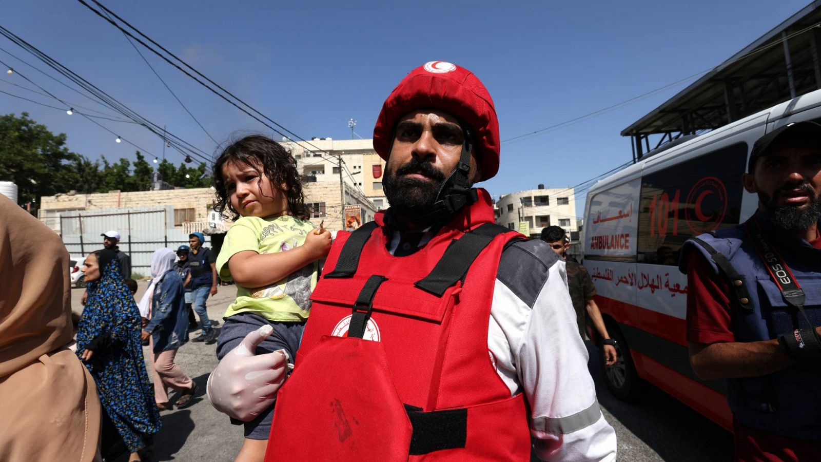 Miembro de Media Luna Roja ayudando a evacuar a un niño