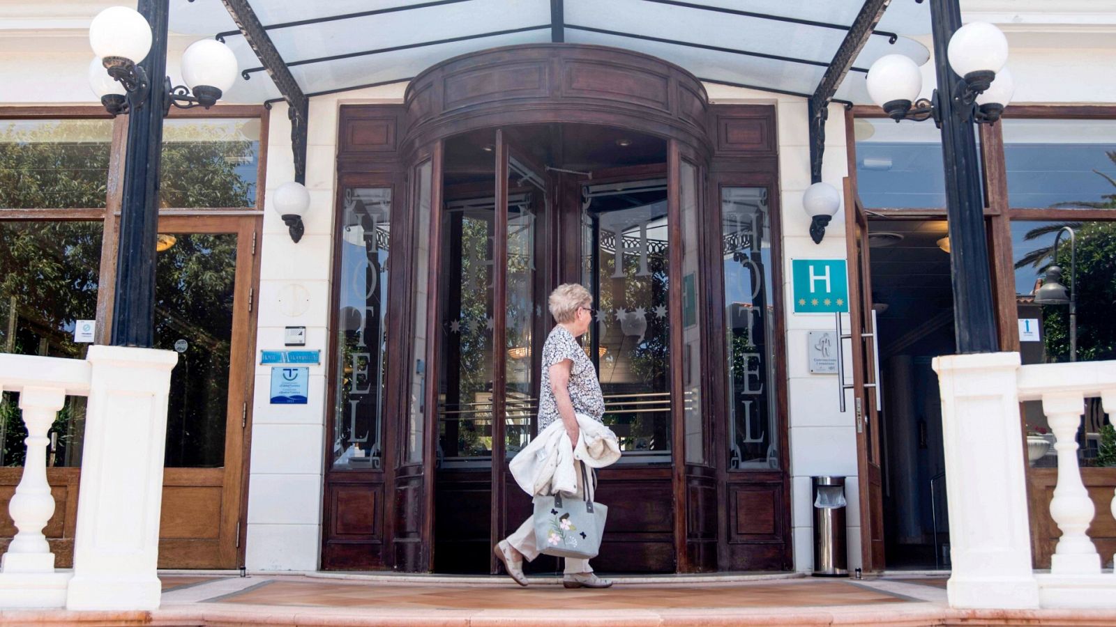 Una mujer camina junto a la entrada de un hotel en Mahón, Menorca, en 2022.