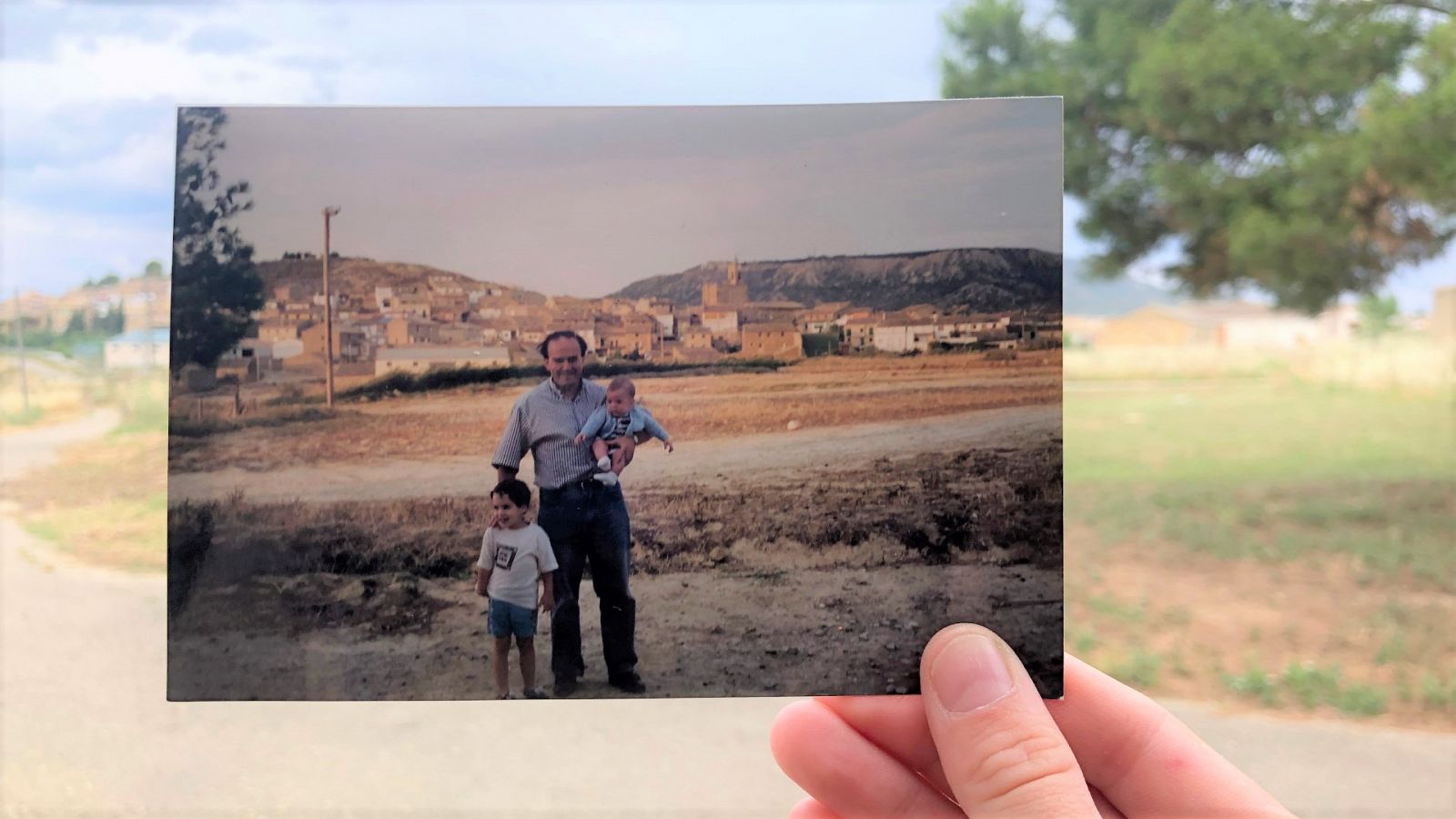 Foto antigua de un padre con sus dos hijos en el pueblo