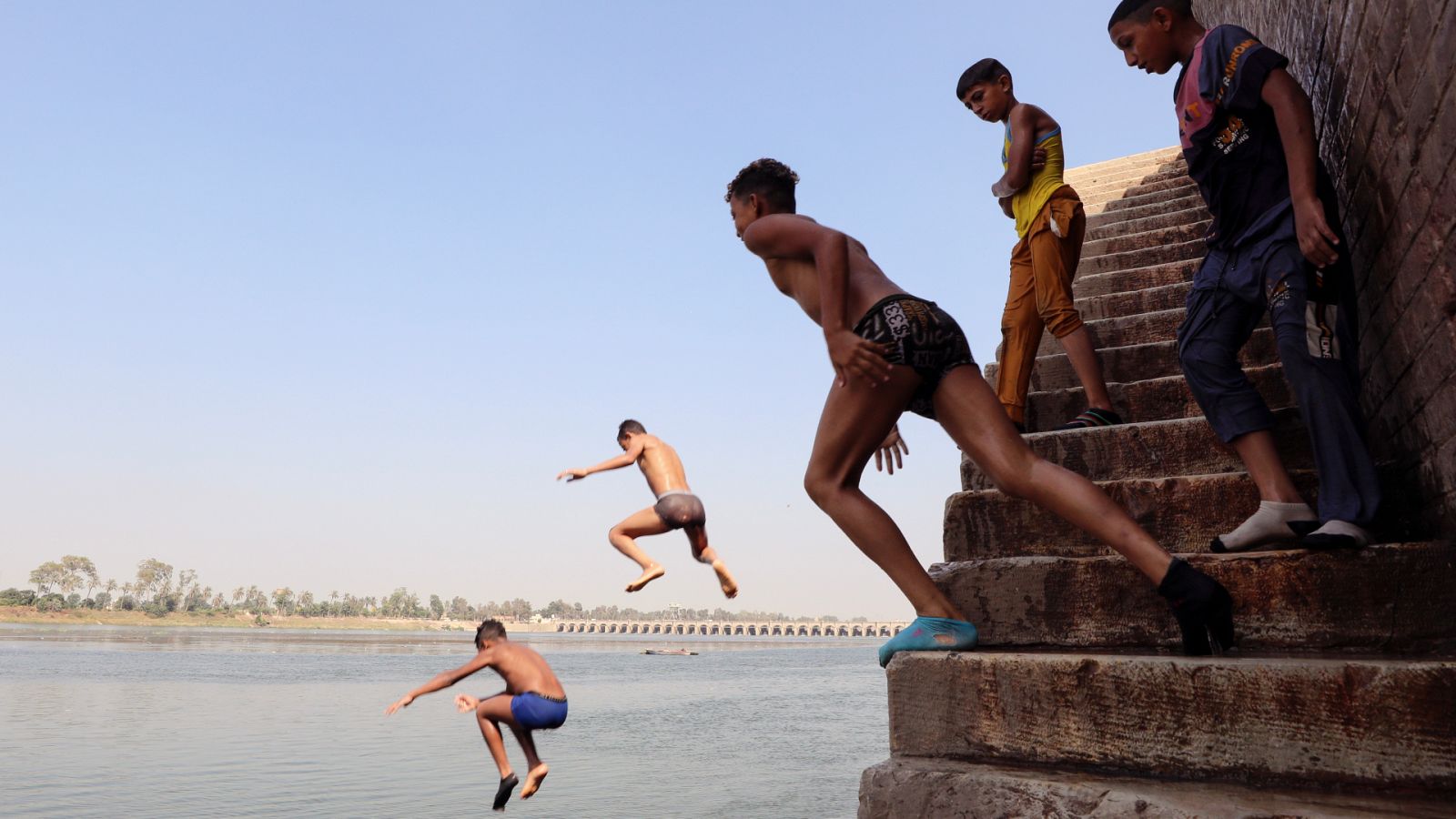 Varios niños se lanzan al Nilo para refrescarse en El Cairo, donde se registran temperaturas de hasta 43ºC.